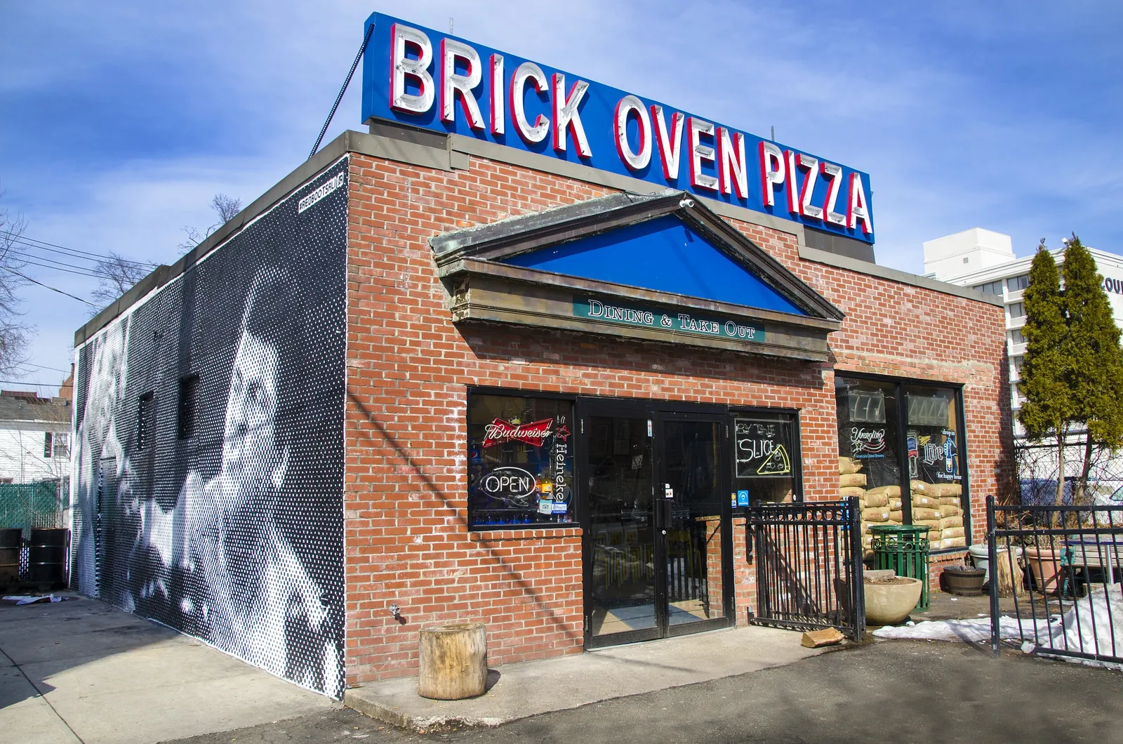 Pizza at the Brick Oven, a large painted portrait mural covering its side wall